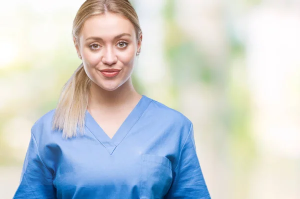 年轻的金发医生医生妇女穿医疗制服在孤立的背景与一个愉快和凉爽的笑容在脸上 幸运的人 — 图库照片