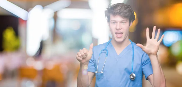 Unga Läkare Bär Medicinsk Uniform Över Isolerade Bakgrund Visar Och — Stockfoto