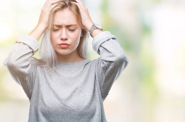 Young blonde woman over isolated background suffering from headache desperate and stressed because pain and migraine. Hands on head.