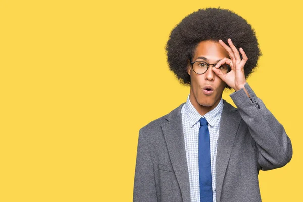 アフロ髪メガネ のジェスチャーを行う若いアフリカ系アメリカ人ビジネスマンは意外そうな顔 目指を通して見るとショックを受けた 疑うような式 — ストック写真