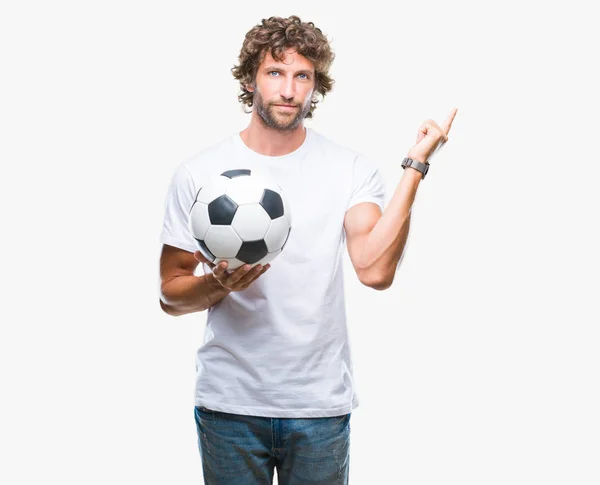 側の手と指で指す非常に幸せの孤立した背景にサッカー サッカー ボールを保持しているハンサムなヒスパニック系男性モデル — ストック写真