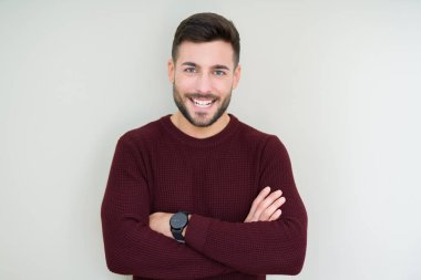 Üzerinde bir kazak giyen genç yakışıklı adam mutlu yüz ile gülümseyerek kameraya seyir silah geçti arka plan izole. Olumlu bir kişi.