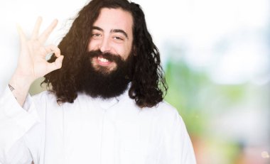 El ve parmak ile ok işareti yapıyor olumlu gülümseyen giyen İsa Mesih kostüm adamım. Başarılı ifade.