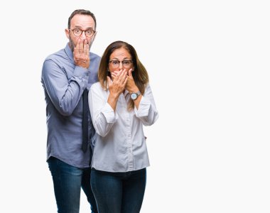 Orta yaş İspanyol çift izole arka plan ağız hata için elleriyle kapsayan şok üzerinde gözlük takan aşık. Gizli kavramı.