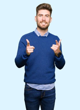 Genç yakışıklı bussines adam kameraya mutlu ve komik suratla parmakları işaret. İyi enerji ve vibes.