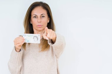 5 pound banknot tutan orta yaş kadın kamera ve size parmak ile işaret arka plan izole, el işareti, pozitif ve kendinden emin bir jest ön