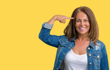 Casual denim ceket izole üzerinde giyen güzel orta yaş kadın arka plan bir parmak, harika bir fikir ya da düşünce, iyi bellek ile baş gösteren gülen