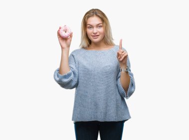 Genç kafkas kadın yemek tatlı çörek üzerinde arka plan ile bir fikir ya da gülen yüz, bir numara ile parmak işaret soru sürpriz izole