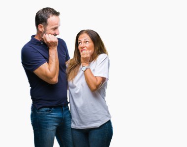 Orta yaş İspanyol rahat çift stresli ve gergin ile izole arka plan üzerinde tırnak ısırma dudaklarından eller. Anksiyete sorunu.