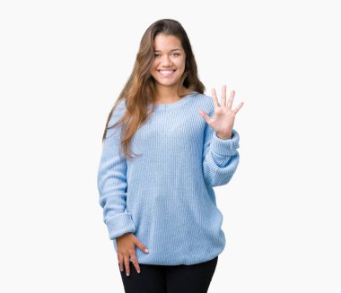 Üzerinde gösterilen ve parmakları ile işaret izole arka plan mavi kış kazak giyen genç güzel esmer kadın kendinden emin ve mutlu gülümseyerek süre beş numara.