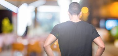 Geriye doğru uzakta silah ile vücut üzerinde seyir izole arka plan ayakta genç yakışıklı adam