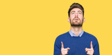 Genç yakışıklı bussines adam hayret ve yukarıya bakıp parmakları ile işaret şaşırttı ve silah kaldırdı.