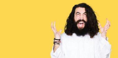 İsa Mesih giyen adam çılgın ve kızgın bağırarak ve agresif ifade ve silah kaldırdı bağırmaya kostüm. Hayal kırıklığı kavramı.