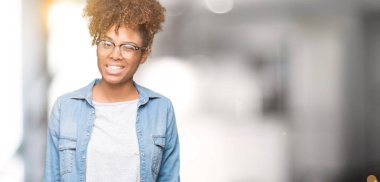 Güzel genç Afro-Amerikan kadın seksi bir ifadeyle, neşeli ve mutlu yüzünü kameraya bakarak göz kırpıyor izole arka plan üzerinde gözlük.