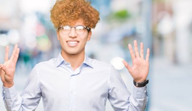 Genç yakışıklı iş adamı ile gösterilen ve parmakları ile işaret gözlüklü afro kendinden emin ve mutlu gülümseyerek süre sekiz numara.