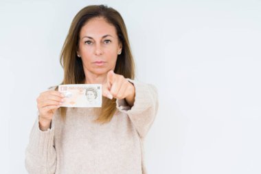 10 pound banknot tutan orta yaş kadın kamera ve size parmak ile işaret arka plan izole, el işareti, pozitif ve kendinden emin bir jest ön