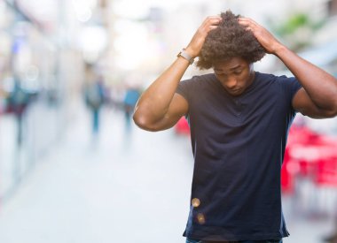 Afro Amerikalı adam çünkü umutsuz ve stresli baş ağrısı acı izole arka plan üzerinde ağrı ve migren. Ellerini kafasına.