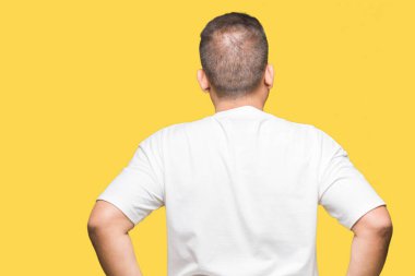 Orta yaş Arap adam wearig t-shirt üzerinde geriye doğru uzakta silah ile vücut üzerinde seyir izole arka plan ayakta beyaz