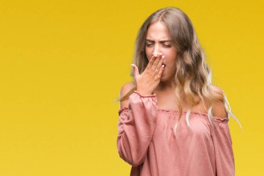 Güzel genç sarışın kadın izole arka plan üzerinde el ile ağız kapsayan yorgun esneme sıkılmış. Restless ve uyku hali.