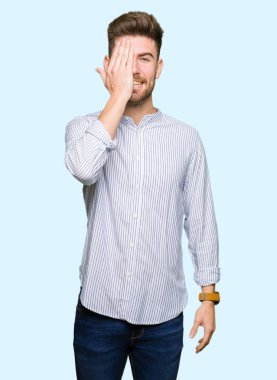 Yakışıklı delikanlı yüz ve sürpriz duygu kendinden emin gülümseme ile el ile bir göz kapsayan.