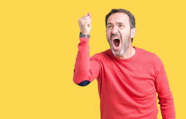 Üzerinde kış kazak giyen yakışıklı orta yaş ağarmış üst düzey adam arka plan kızgın izole ve kızgın yetiştirme hayal kırıklığı ve öfke ile bağırarak süre öfkeli yumruk. Öfke ve agresif kavramı.