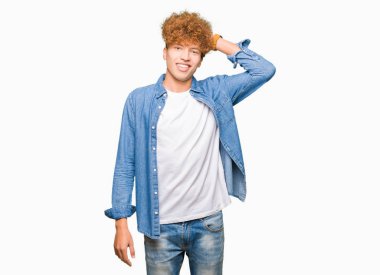 Denim ceket Gülen hareketi, el ile'deki emin dokunaklı saç giyen afro saçlı Genç yakışıklı adam çekici poz