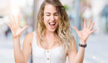 Genç güzel sarışın kadın deli ve silah ile başarı için deli kutluyor izole arka plan üzerinde kaldırdı ve heyecanlı çığlık gözler kapalı. Kazanan kavramı