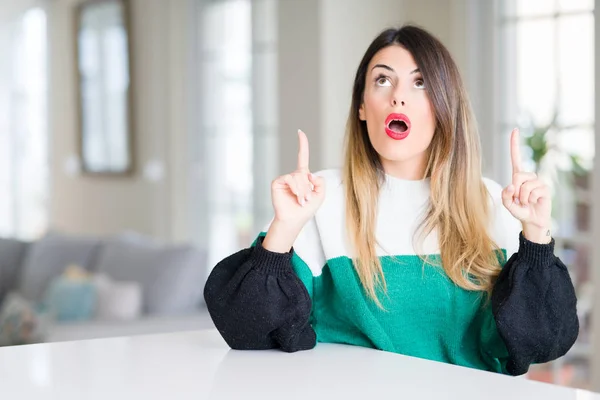 Mooie Jongedame Dragen Winter Trui Thuis Verbaasd Verrast Opzoeken Wijzen — Stockfoto