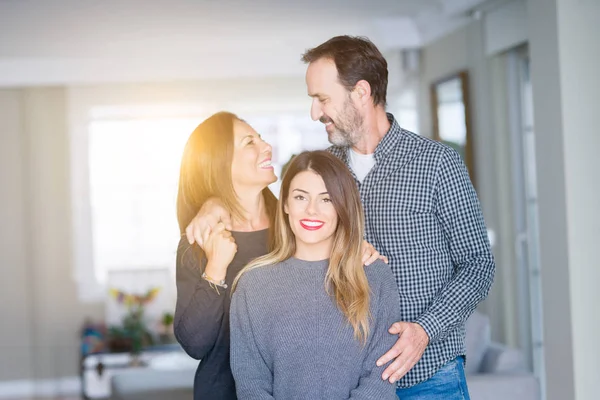 Güzel aile birlikte. Anne, baba ve kızı gülümseyen ve evde sevgi ile sarılma.