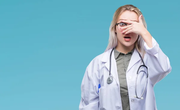 Young Blonde Doctor Woman Isolated Background Peeking Shock Covering Face — Stock Photo, Image