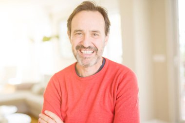 Evde kameraya bakarak gülümseyen yakışıklı orta yaş erkek