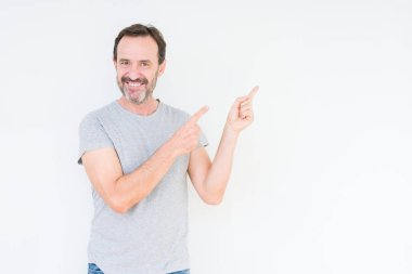 Gülümseyen ve iki elleri ve parmakları ile tarafına işaret kamera bakarak izole arka plan üzerinde üst düzey yakışıklı.