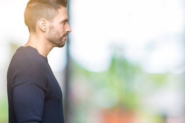 Genç yakışıklı adam giyen kazak izole arka tarafına, seyir üzerinde dinlenmek doğal yüz emin gülümseme ile pozuyla profili.