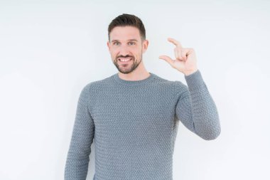 Yakışıklı genç gülümseyen izole arka plan ve süre seyir ve kamera boyutu işaret parmaklarıyla yapıyor el ile kendinden emin eller üzerinde rahat kazak giyiyor. Ölçü kavramı.