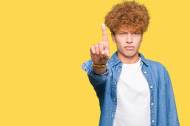 Afro saçlı kot giyen genç yakışıklı adam ceket işaret parmağını ve kızgın ifade ile