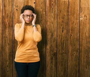 Genç güzel Afrikalı-Amerikalı kadın üzerinde gözlük takan izole arka plan baş baş ağrısı için el ile çünkü stres. Migren muzdarip.