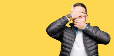 Yakışıklı adam giyen kış kapsayan gözler kat ve ağız şaşırttı ve şok elleriyle. Duygu gizleme