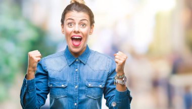 İzole arka plan kutlama üzerinde genç güzel kadın şaşırttı ve başarı için kaldırdı kollarını açarak hayret ve gözleri açık. Kazanan kavramı.