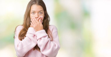 Üzerinde pembe kış kazak giyen genç güzel esmer kadın arka plan ağız hata için elleriyle kapsayan şok izole. Gizli kavramı.