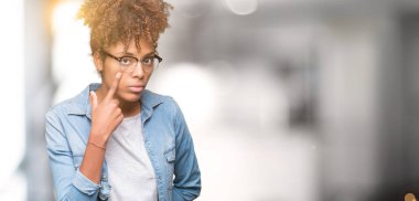 Güzel genç Afro-Amerikan kadın gözlük izole üzerinde arka plan işaret jest göz izlemek için şüpheli ifade