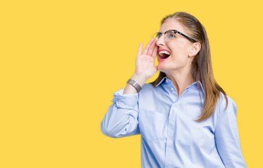 Güzel orta yaş olgun iş kadını bağırarak ve ağzı üzerinde el ile yan için çığlık izole arka plan üzerinde gözlük takıyorum. İletişim kavramı.