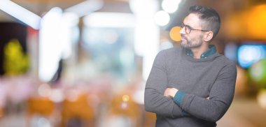 İkna ve kendine güvenen tarafına silahlarla seyir gülümseyen izole arka plan üzerinde gözlük takan genç yakışıklı adam geçti