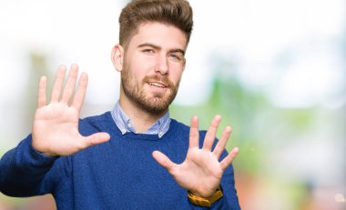 Genç yakışıklı bussines çerçeve kullanarak el avuç içi ve parmaklar, kamera perspektif yapıyor gülen adam