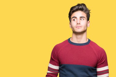 Yakışıklı delikanlı görünümlü yan ve dik dik bakma uzağa düşünce gülümseyen izole arka plan üzerinde.