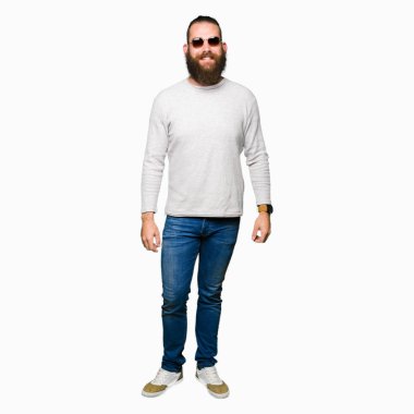 Genç hipster adam yüzünde mutlu ve güzel bir gülümseme ile güneş gözlüğü takıyor. Şanslı kişi.