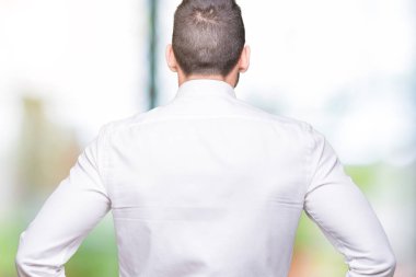 İzole arka plan ayakta geriye doğru uzakta silah ile vücut üzerinde seyir üzerinde gözlük takan genç yakışıklı iş adamı