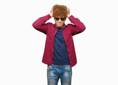 Yakışıklı genç afro saçlı giyen güneş gözlüğü çünkü umutsuz ve stresli baş ağrısı acı acı ve migren. Ellerini kafasına.