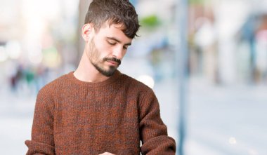 Kol saati, rahat ve kendinden emin zamanında kontrol izole arka plan üzerinde kış kazak giyen genç yakışıklı adam