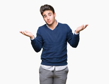 Genç yakışıklı iş adamı izole arka plan clueless ve şaşkın bir ifadeyle kollar ve eller ortaya çıkar üzerinden. Şüphe kavramı.