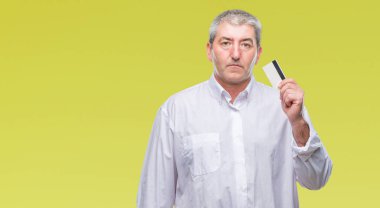 Kredi kartı ile acımak yüz ciddi düşünme emin bir ifade izole arka plan üzerinde tutarak yakışıklı komuta sizde